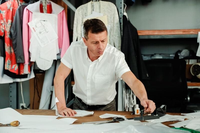 pattern making: Man adding a marker to a piece of fabric