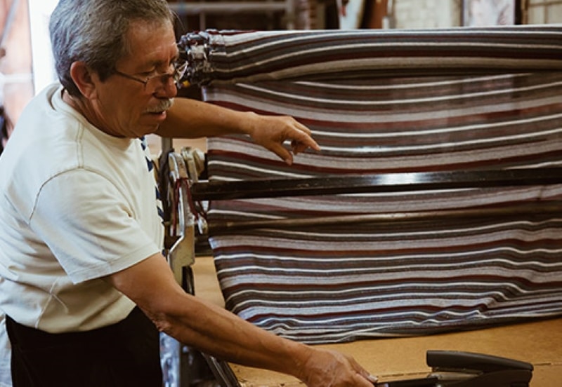 fabric sourcing: Elderly man cutting fabric
