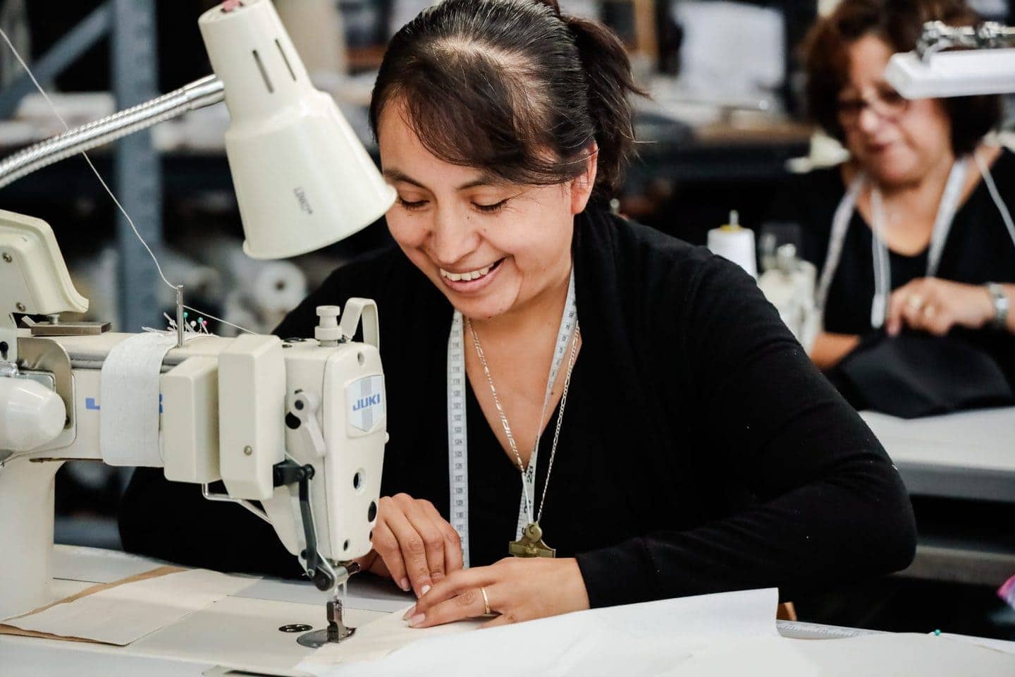 Smiling woman using a sewing machine