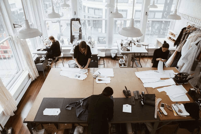 Group of people working in a small fashion production studio