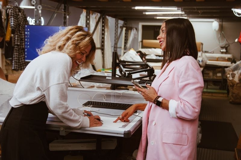 two women smiling while working