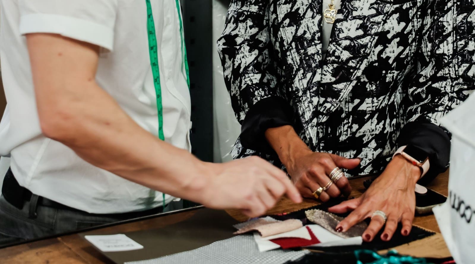 Two clothing manufacturers examining fabric