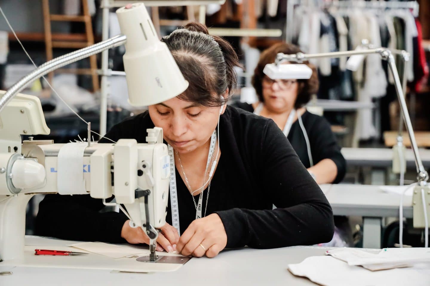 Los Angeles cut and sew seamstress working on a clothing sample at a sewing machine