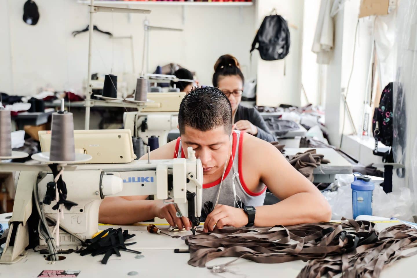 Closeup view of Los Angeles cut and sew clothing manufacturer working on a clothing sample at a sewing machine