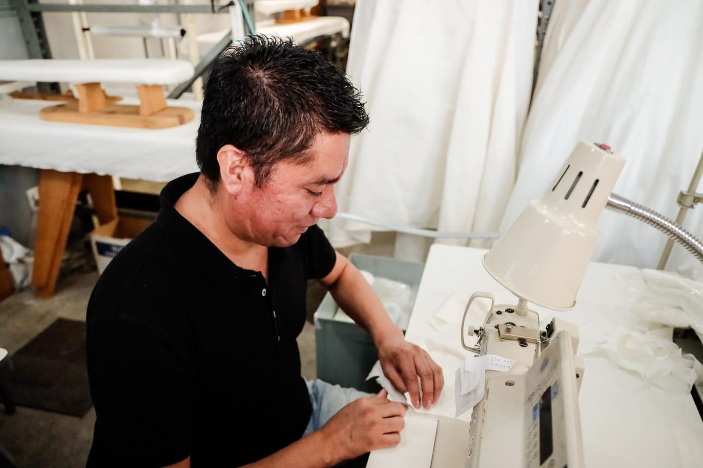 Side profile of samplemaker Balthazar at the sewing machine