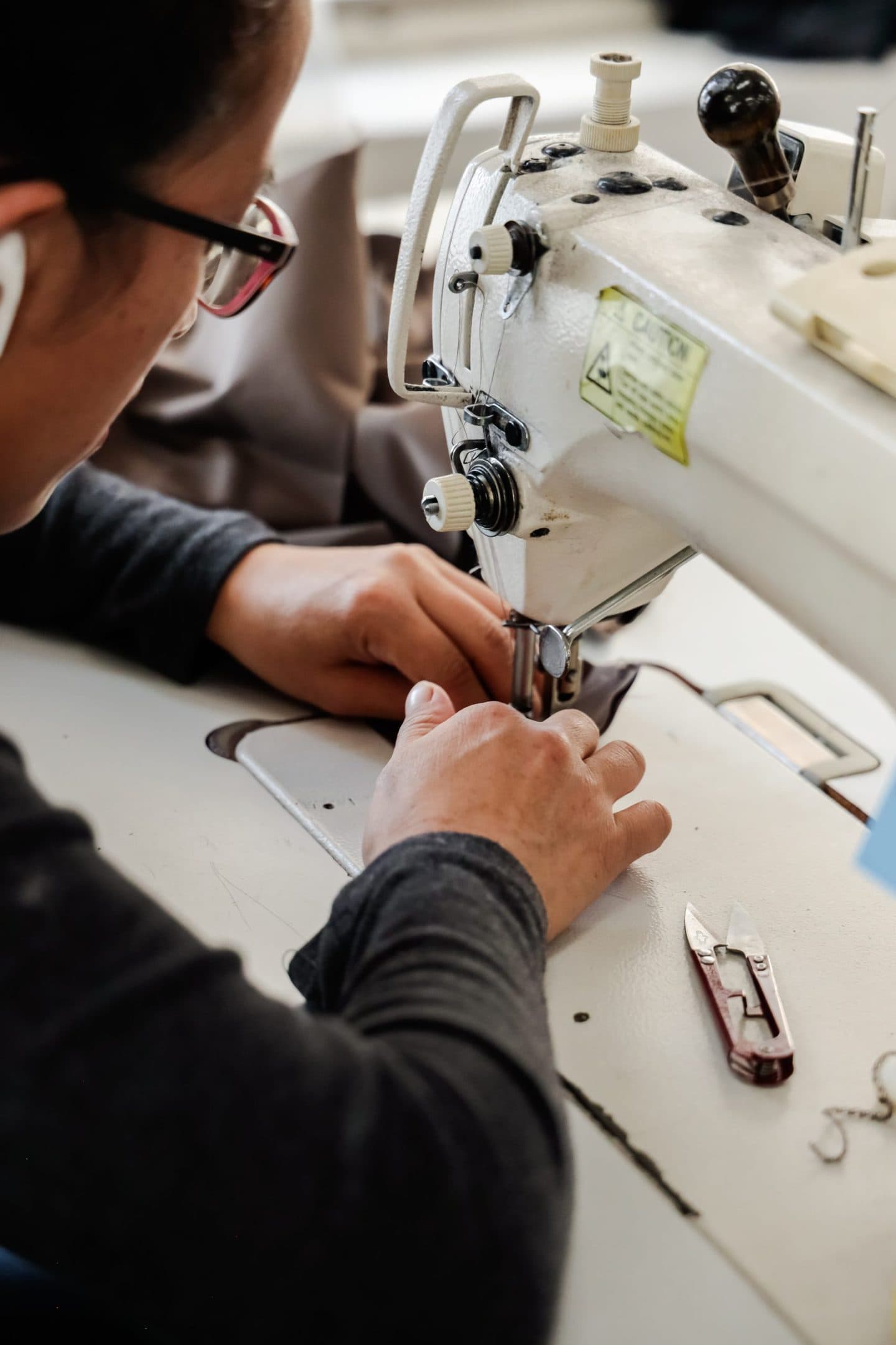 Closeup of a Los Angeles clothing manufacturer using a sewing machine