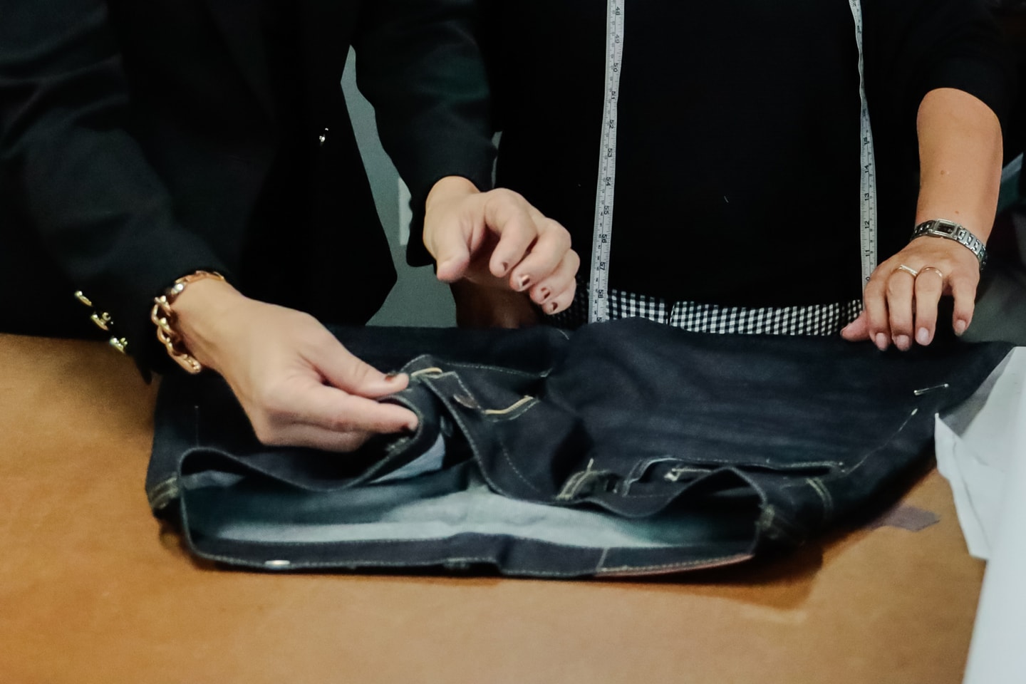 Two fashion designers examining a pair of jeans