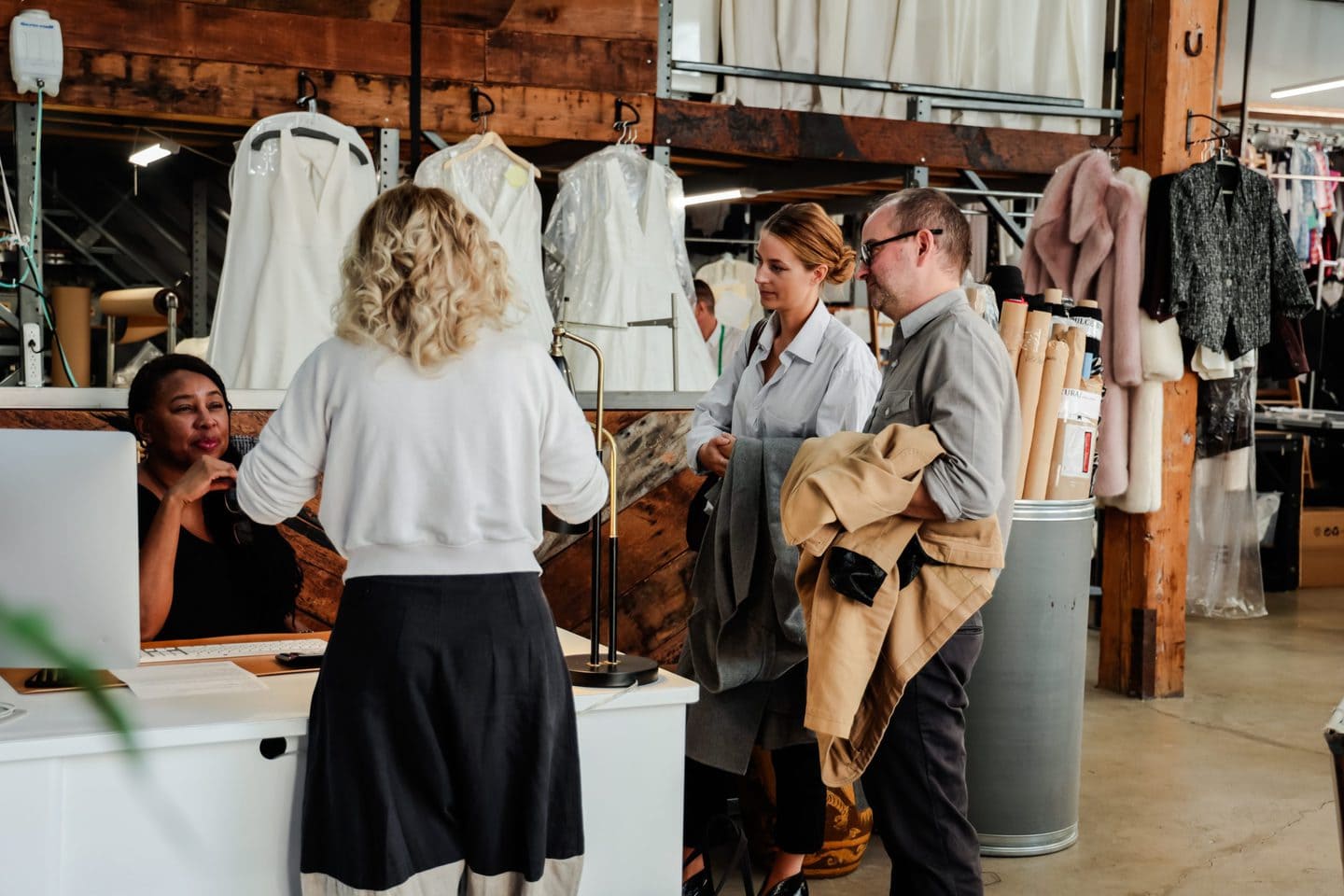 four american clothing manufacturers standing around a table