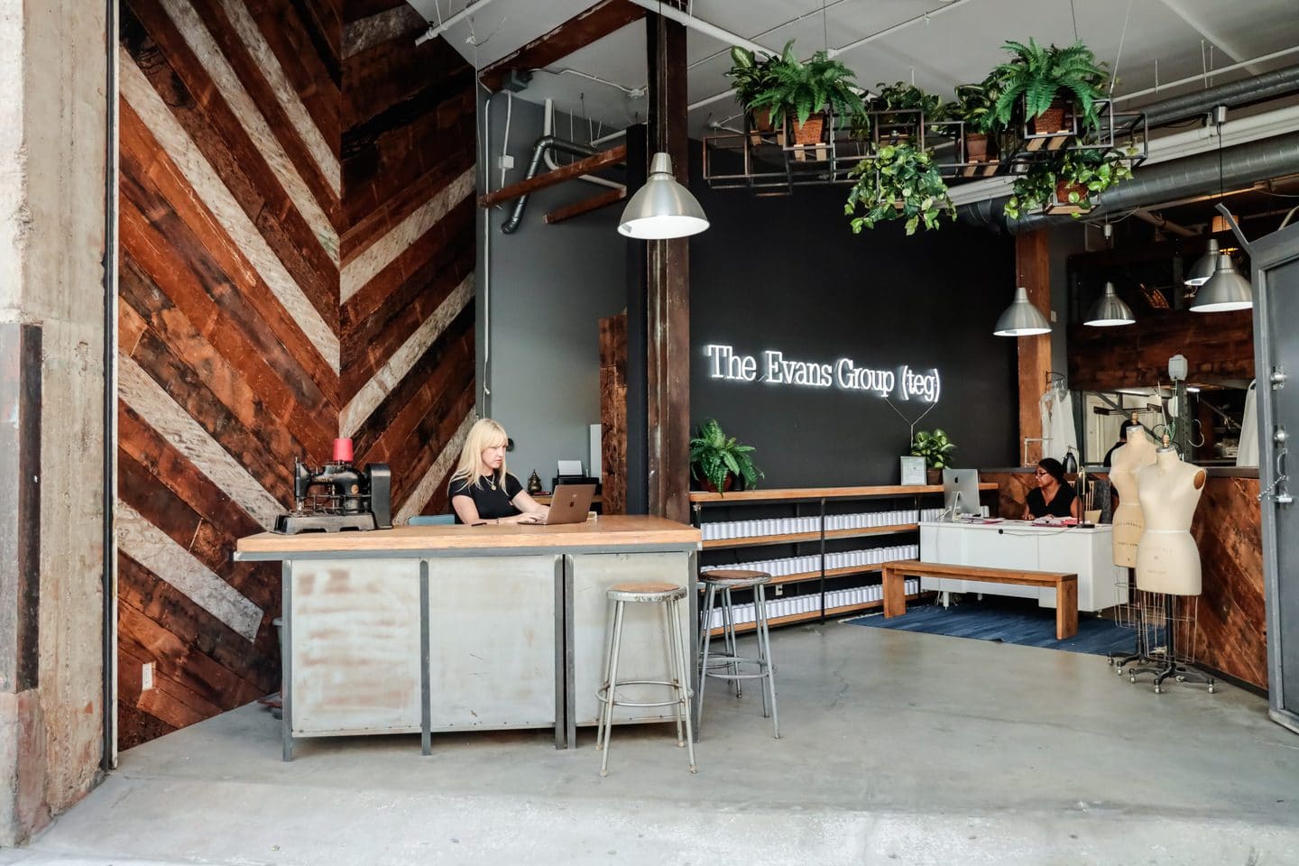 Jennifer Evans sitting at the front desk of her American clothing manufacturing studio in Los Angeles