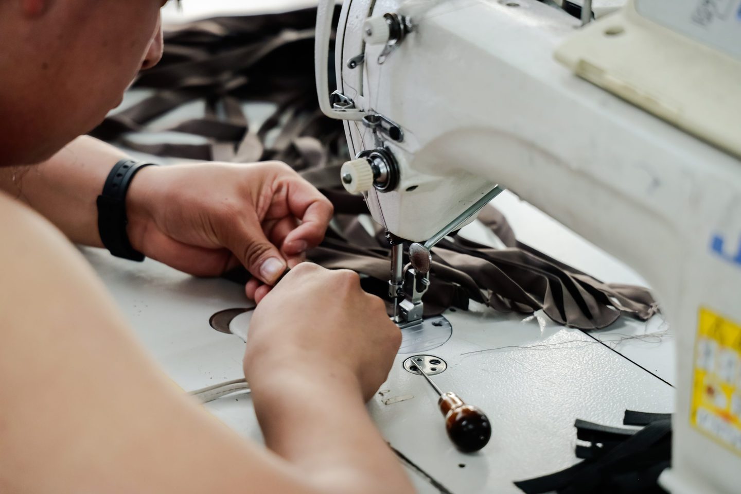 slow fashion tailor working at a sewing machine on clothing lines